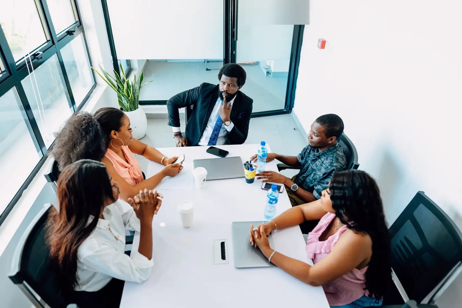 Les membres d'un bureau d'association en réunion autour d'une table, dans un bureau lumineux